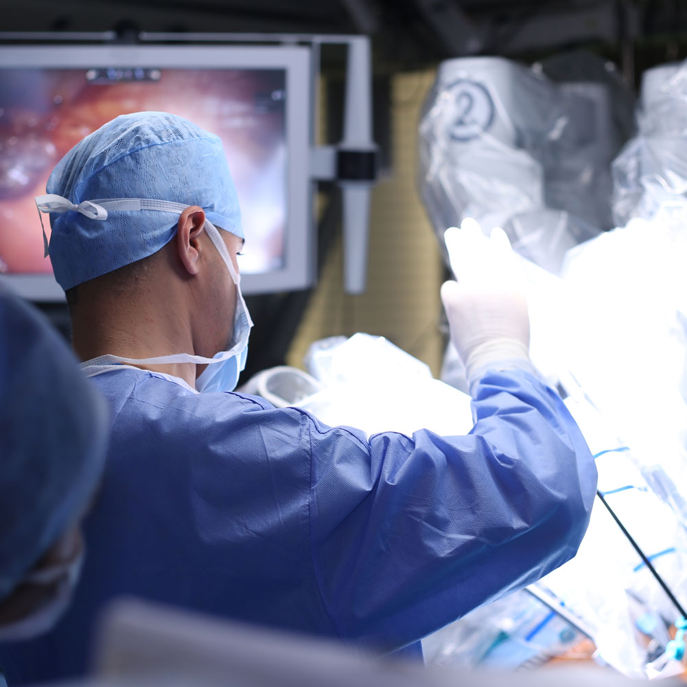 A surgical assistant beside the operating theatre display.
